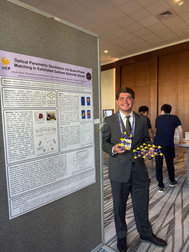 Jacob standing in front of his research poster on Optical Parametric Oscillation via Quasi-Phase Matching in Exfoliated Gallium Selenide Stacks