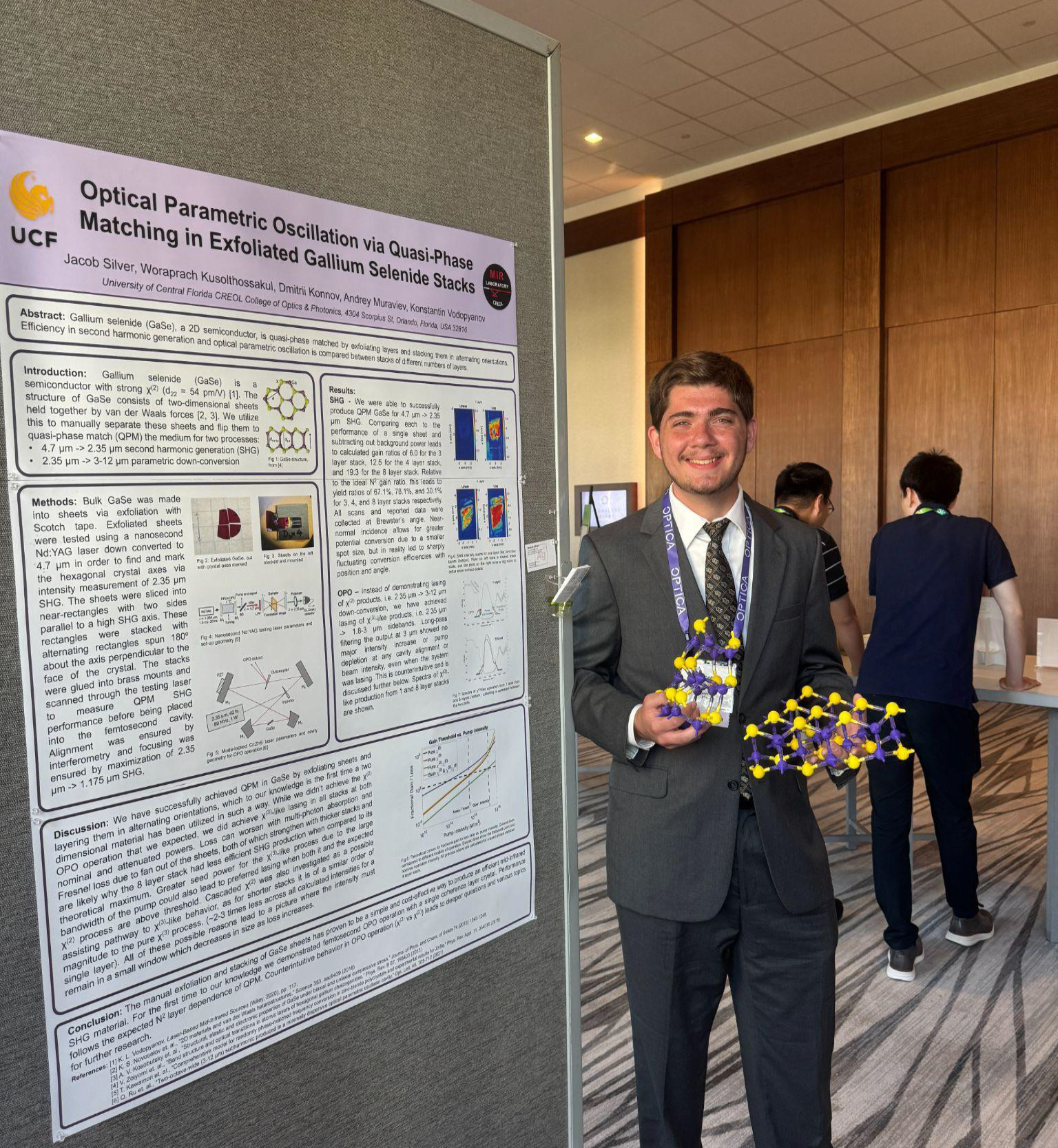 Jacob standing in front of his research poster on Optical Parametric Oscillation via Quasi-Phase Matching in Exfoliated Gallium Selenide Stacks